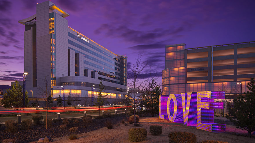 Purple LOVE sculpture outside of Renown Regional Medical Center at dusk