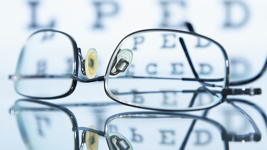 Myopic spectacles with a Snellen eye chart in the background