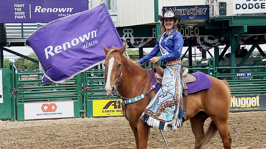 Miss Rodeo Nevada 2022 Gabby Szachara on her horse Torque holding Renown flag in the Reno Rodeo arena