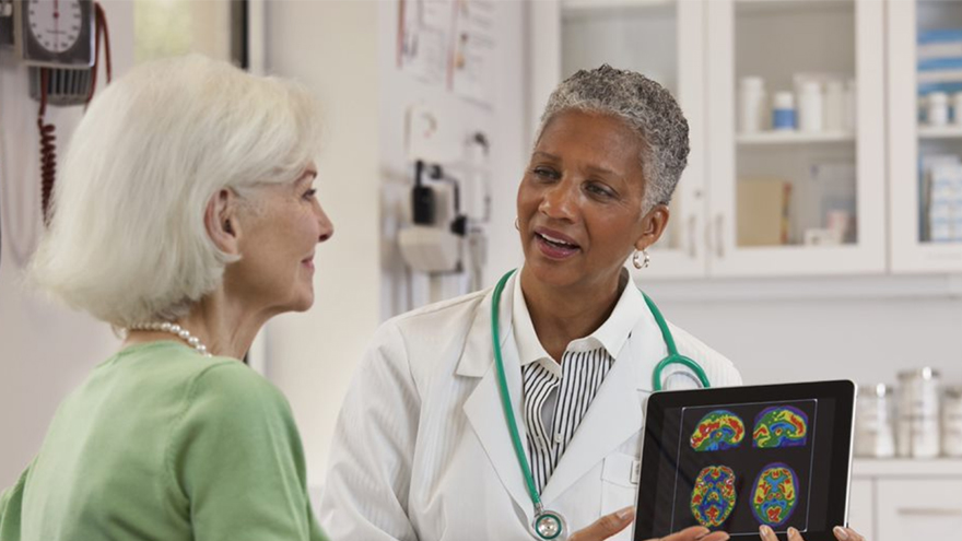 female doctor showing brain scans to senior woman patient